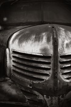 Image of an old rusty Chevrolet in black and white.