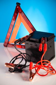 Car battery with two jumper cables clipped on vivid moto concept