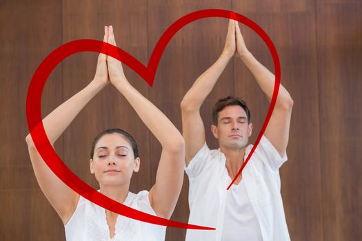 Peaceful couple in white doing yoga together with hands raised against heart