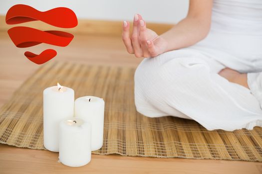 Woman sitting in lotus pose beside white candles against heart