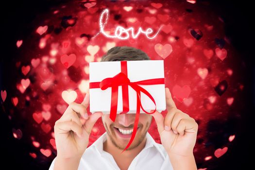 Man holding gift against valentines heart design