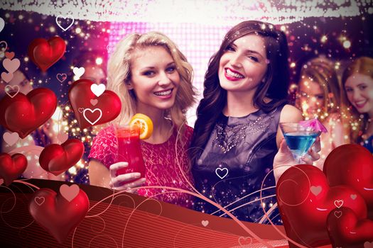 Friends drinking cocktails against valentines heart design