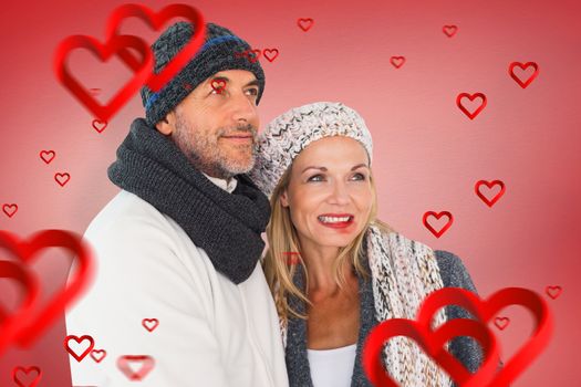 Happy couple in winter fashion embracing against red vignette