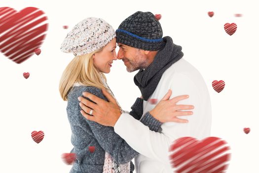 Happy couple in winter fashion embracing against hearts