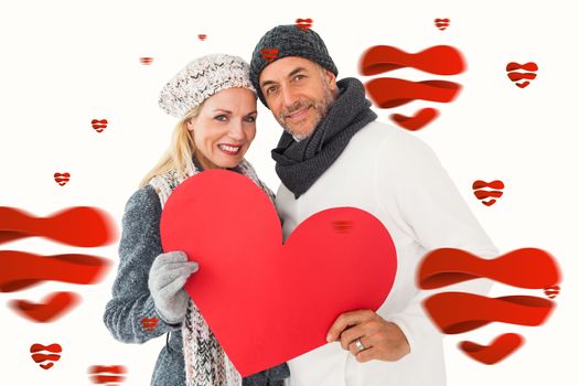 Smiling couple in winter fashion posing with heart shape against hearts