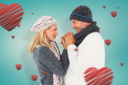 Couple in winter fashion embracing against blue vignette background