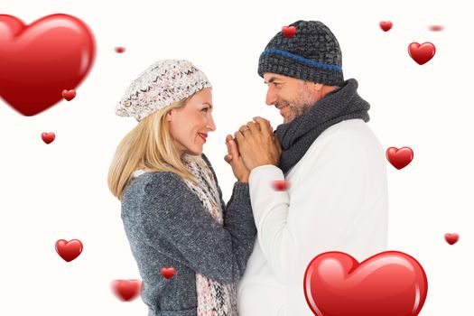 Couple in winter fashion embracing against hearts