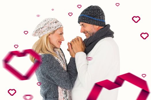 Couple in winter fashion embracing against hearts