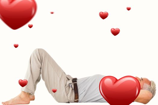 Smiling man lying and looking up against hearts