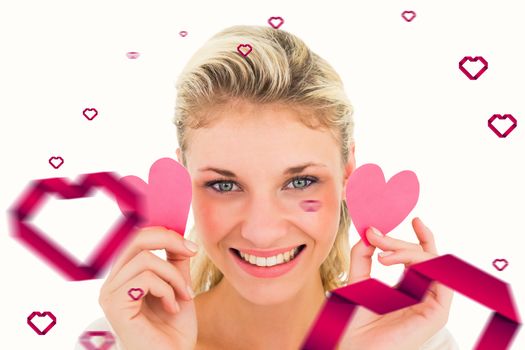 Attractive young blonde holding little hearts  against hearts