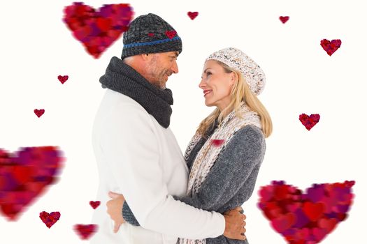 Happy couple in winter fashion embracing against hearts