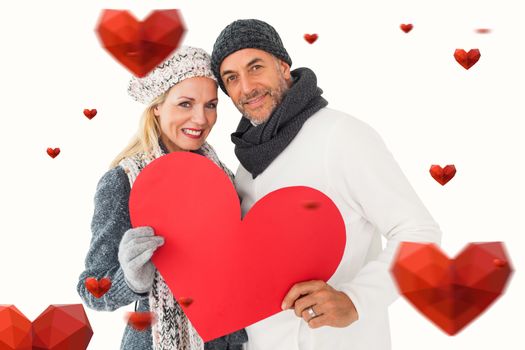 Smiling couple in winter fashion posing with heart shape against hearts