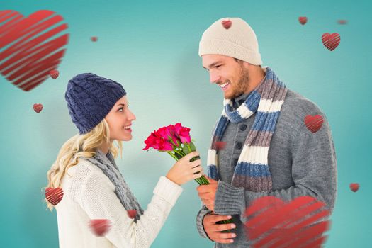 Attractive man in winter fashion offering roses to girlfriend against blue vignette background