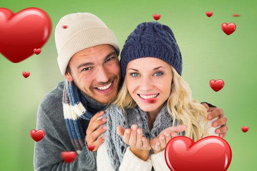 Attractive couple in winter fashion smiling at camera against green vignette