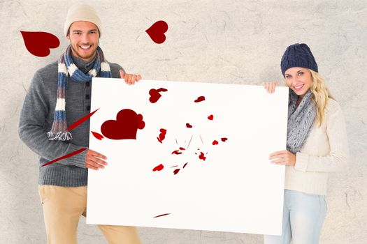 Attractive couple in winter fashion showing poster against parchment