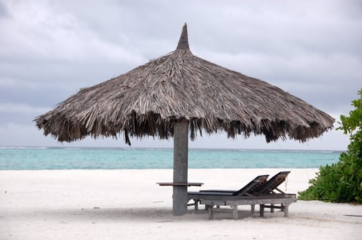 Deck chair and big umbrella at beach, Maldives