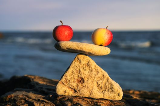 Balancing of two apples on the top of stone