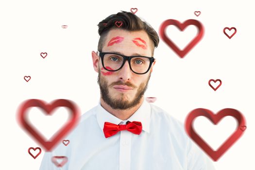 Geeky hipster with kisses on his face against hearts