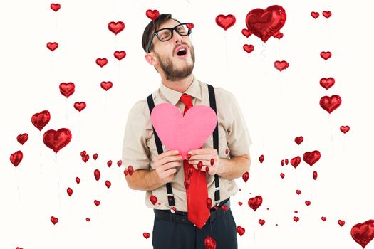 Geeky hipster crying and holding heart card against red heart balloons floating