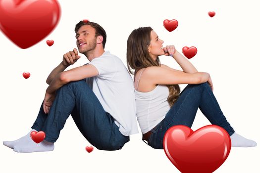 Young couple sitting on floor against hearts