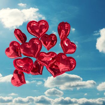 Heart balloons against sky and clouds