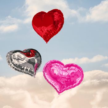 Love heart balloons against cloudy sky