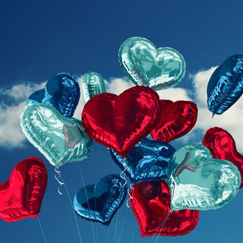 Heart balloons against sky 