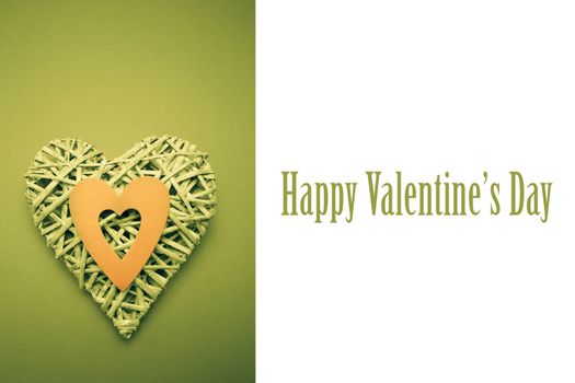 Wicker heart ornament with green paper cut out against cute valentines message