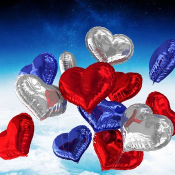 Heart balloons against white clouds under blue sky