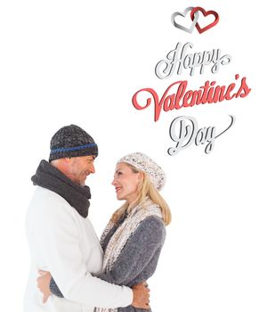 Happy couple in winter fashion embracing against cute valentines message