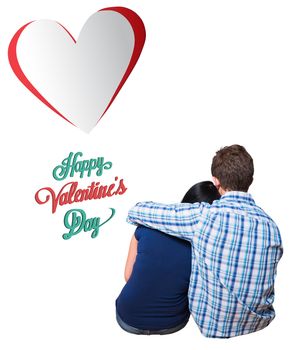 Young couple sitting on floor against happy valentines day