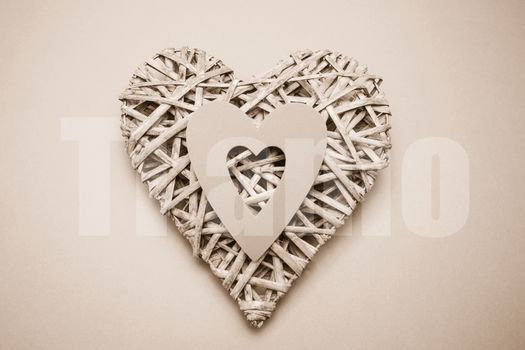 Wicker heart ornament with paper cut out against ti amo