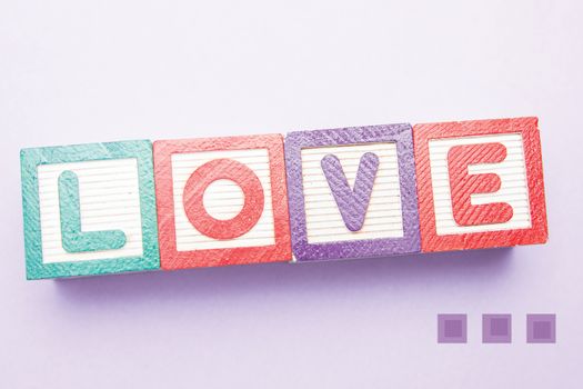 Building blocks spelling out love against cute valentines message