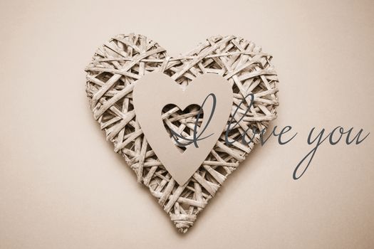 Wicker heart ornament with paper cut out against i love you