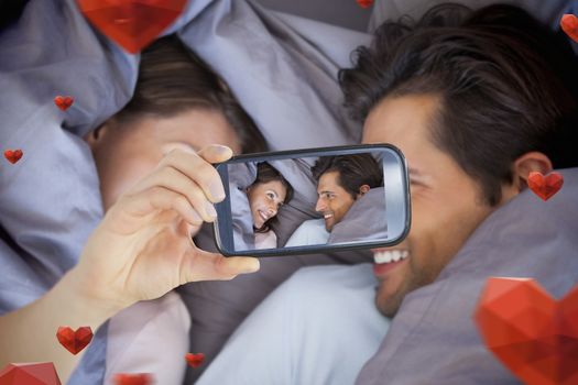 Composite image of valentines couple taking a selfie