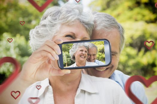 Composite image of valentines couple taking a selfie