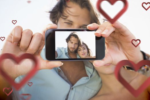 Composite image of valentines couple taking a selfie