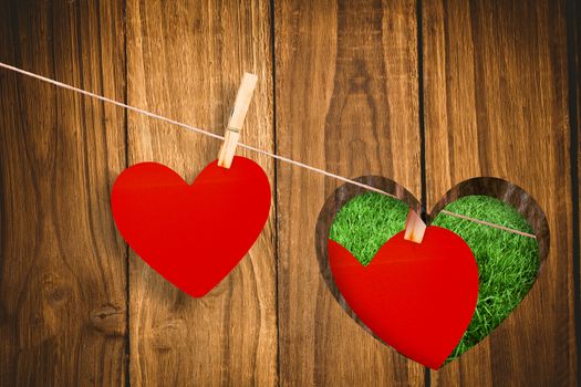 Hearts hanging on a line against heart in wood