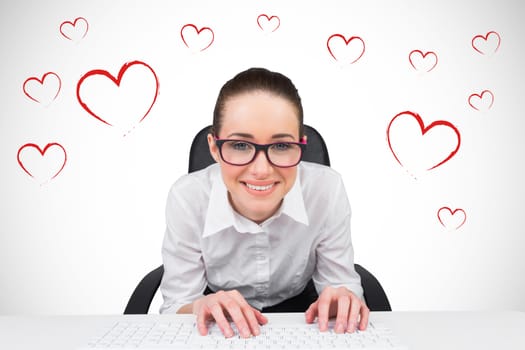 Businesswoman typing on a keyboard against white background with vignette