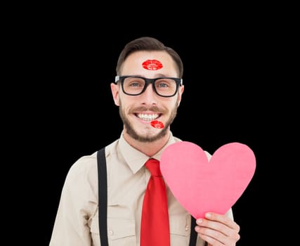 Geeky hipster smiling and holding heart card against black