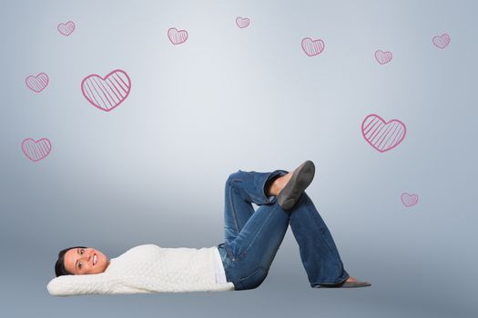 Young woman lying on floor smiling against grey vignette