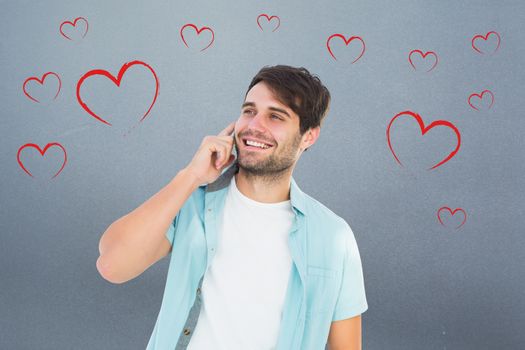 Happy casual man talking on phone against grey