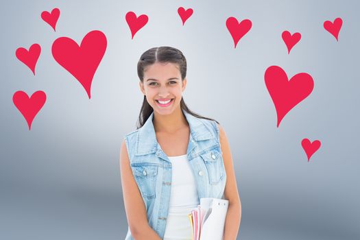 Student holding notepads against grey vignette