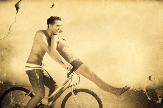 Man giving girlfriend a lift on his crossbar against grey background