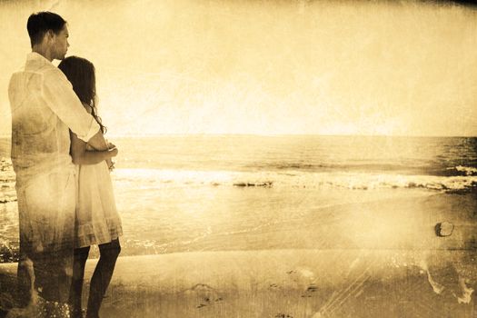 Attractive couple looking out at sea against grey background