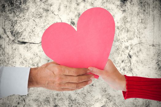 Couple holding heart against grey background