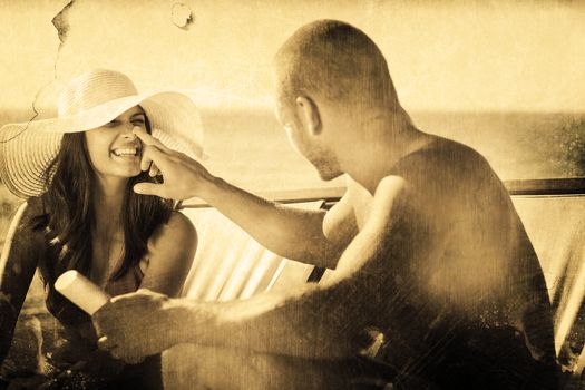 Handsome man applying sun cream on his girlfriends nose against grey background