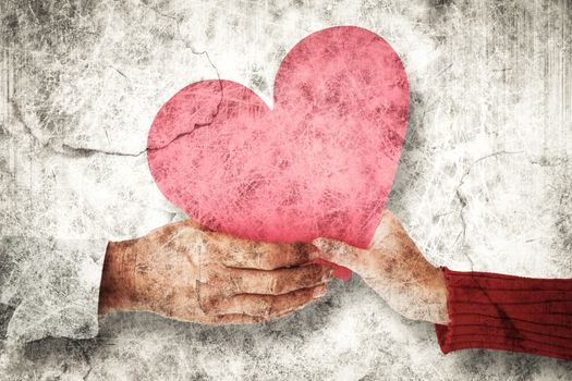 Couple holding heart against grey background