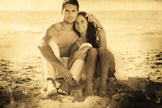 Cuddling couple smiling at camera against grey background