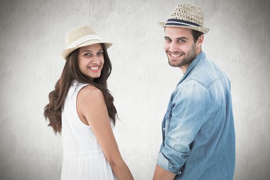 Happy hipster couple holding hands and smiling at camera against white background